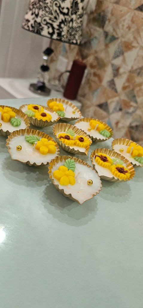 A group of Maelora floral diya urlis with yellow flowers and sunflowers