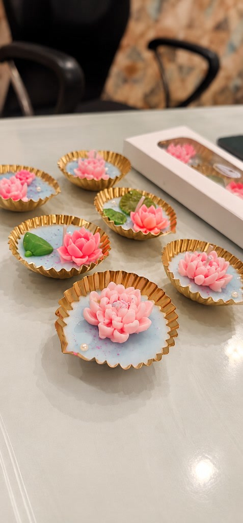 Lotus diya urlis by Maelora with pink lotus blooms on aqua wax in gold cups