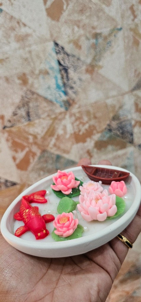 Handheld Maelora Lotus Koi Bowl Candle showing the size of the oval bowl