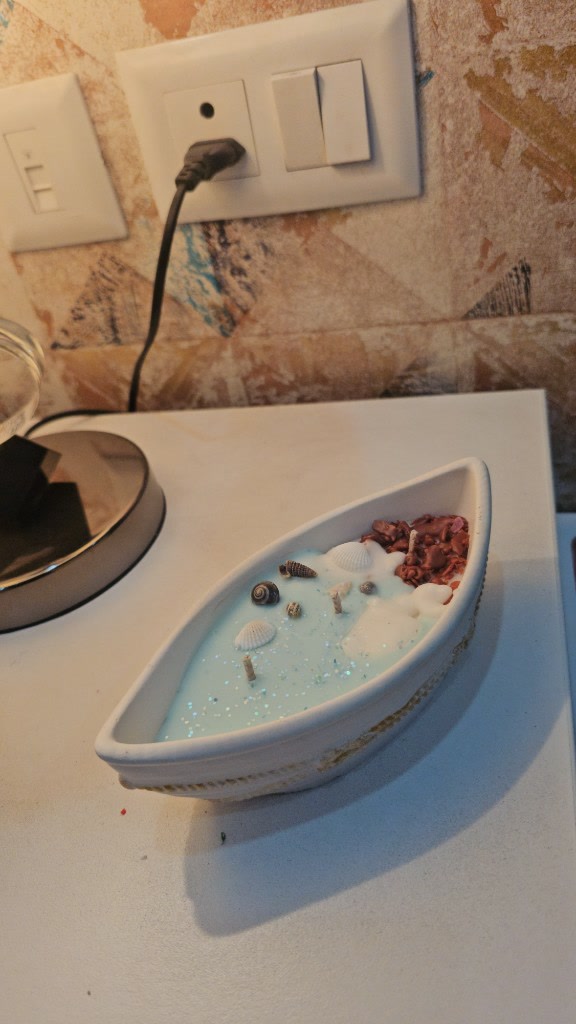 Alternate view of the Maelora Seashell Boat Candle with aqua-blue wax, seashells and coral-inspired details